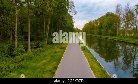 Schöne Sicht auf den Dessel-Schoten Kanal in Belgien. Pfad oder Fußweg am Wasser entlang. Pfad, der am Fluss vorbeiführt. Sonniger Tag. Landschaft mit Pfad, Bäumen, Fluss. Hochwertige Fotos Stockfoto