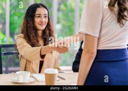 Nahaufnahme Handshake nach Interview Vereinbarung zwischen Young Asian Frau und zwei Manager mit positiver Bewegung im Besprechungsraum, Handshake mit Manager, BU Stockfoto