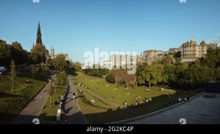 Viele Menschen ruhen sich auf Gras in Princes Street Gardens, Edinburgh, Schottland, Großbritannien. Juni 2021 Stockfoto