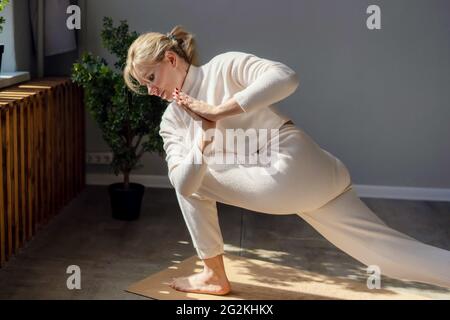 Schlanke, flexible Frau, die im Fitnessstudio Yoga macht. Sich um die körperliche und geistige Gesundheit kümmern. Stockfoto