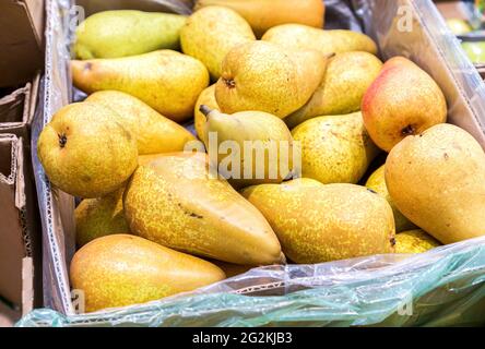 Frische Birnen der neuen Ernte in der Pappschachtel im Lebensmittelgeschäft Stockfoto