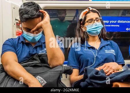 London, Großbritannien. Juni 2021. Erschöpfte Mitglieder des Impfteams von Guy's und St. Thomas fahren in der Londoner U-Bahn nach Hause. Kredit: Guy Bell/Alamy Live Nachrichten Stockfoto