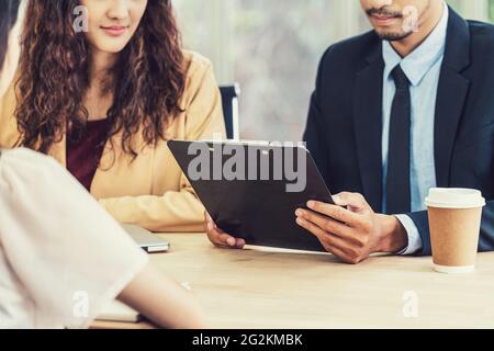 Nahaufnahme Wiederaufnehmen in zwei Händen des Managers, wenn Sie über sprechen Ihr Lebenslauf mit Glück Bewegung über junge asiatische Frau Absolvent Interviews in Meetings Stockfoto
