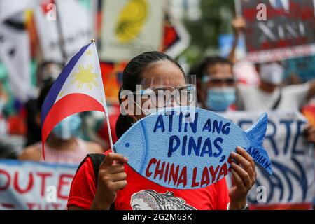 Metro Manila, Philippinen. Juni 2021. Ein Aktivist hält ein Plakat vor dem chinesischen Konsulat während eines Protestes zum Unabhängigkeitstag im Finanzviertel von Makati. Verschiedene Gruppen forderten China auf, seine maritimen Aktivitäten im umstrittenen Südchinesischen Meer einzustellen, was Frieden und Stabilität in der Region gefährdet. Kredit: Majority World CIC/Alamy Live Nachrichten Stockfoto