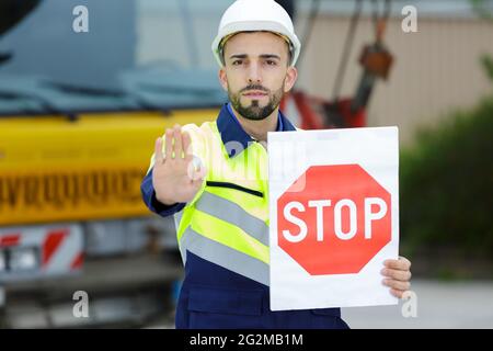Handwerker, die eine Stop-Schild Stockfoto