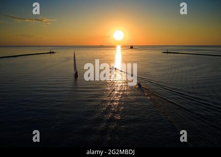 Riga, Lettland 12-06-2021 Segelyacht gegen Sonnenuntergang. Urlaub Lifestyle Landschaft mit Skyline Segelboot. Yachting Tourismus - maritimer Abendspaziergang. Rom Stockfoto