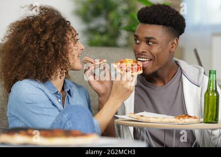 Glückliches Paar, das zu Hause Pizza isst Stockfoto