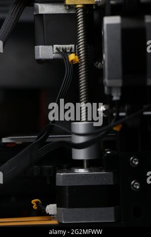 Die Drähte werden mit den Steppmotoren des 3d-Druckers verbunden, wobei die Gewindestange sichtbar ist, die zum 3D-Druckprozess beiträgt Stockfoto