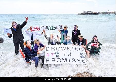 Worthing Sussex UK 12. Juni 2021 - Aktivisten des Extinction Rebellion werden im Meer nass, als sie heute an einem Protest am Worthing Beach teilnehmen, der im Rahmen eines Aktionswochenendes anlässlich des G7-Gipfels stattfindet und die Auswirkungen des Klimawandels und des steigenden Meeres beleuchtet Levels : Credit Simon Dack / Alamy Live News Stockfoto