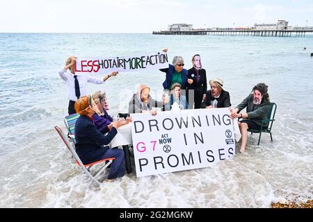 Worthing Sussex UK 12. Juni 2021 - Aktivisten des Extinction Rebellion werden im Meer nass, als sie heute an einem Protest am Worthing Beach teilnehmen, der im Rahmen eines Aktionswochenendes anlässlich des G7-Gipfels stattfindet und die Auswirkungen des Klimawandels und des steigenden Meeres beleuchtet Levels : Credit Simon Dack / Alamy Live News Stockfoto