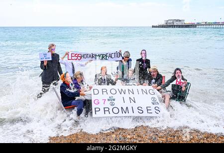 Worthing Sussex UK 12. Juni 2021 - Aktivisten des Extinction Rebellion werden im Meer nass, als sie heute an einem Protest am Worthing Beach teilnehmen, der im Rahmen eines Aktionswochenendes anlässlich des G7-Gipfels stattfindet und die Auswirkungen des Klimawandels und des steigenden Meeres beleuchtet Levels : Credit Simon Dack / Alamy Live News Stockfoto