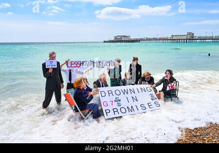 Worthing Sussex UK 12. Juni 2021 - Aktivisten des Extinction Rebellion werden im Meer nass, als sie heute an einem Protest am Worthing Beach teilnehmen, der im Rahmen eines Aktionswochenendes anlässlich des G7-Gipfels stattfindet und die Auswirkungen des Klimawandels und des steigenden Meeres beleuchtet Levels : Credit Simon Dack / Alamy Live News Stockfoto