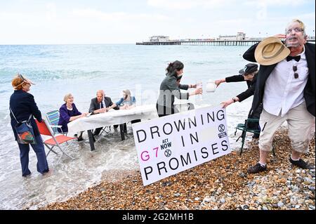 Worthing Sussex UK 12. Juni 2021 - Aktivisten des Extinction Rebellion werden im Meer nass, als sie heute an einem Protest am Worthing Beach teilnehmen, der im Rahmen eines Aktionswochenendes anlässlich des G7-Gipfels stattfindet und die Auswirkungen des Klimawandels und des steigenden Meeres beleuchtet Levels : Credit Simon Dack / Alamy Live News Stockfoto