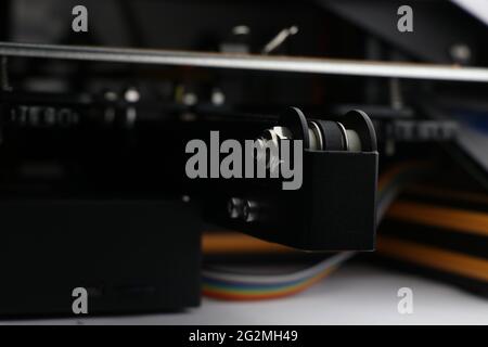 Bett, auf dem der 3D-Druckprozess mit sichtbarem Heizbett und einer Reihe von Drähten im Hintergrund stattfindet Stockfoto