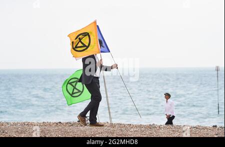 Worthing Sussex UK 12. Juni 2021 - Aktivisten des Extinction Rebellion nehmen heute am Worthing Beach Teil an einem Aktionswochenende anlässlich des G7-Gipfels und heben die Auswirkungen des Klimawandels und des steigenden Meeresspiegels hervor: Credit Simon Dack / Alamy Live News Stockfoto