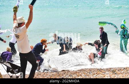 Worthing Sussex UK 12. Juni 2021 - Aktivisten des Extinction Rebellion werden im Meer nass, als sie heute an einem Protest am Worthing Beach teilnehmen, der im Rahmen eines Aktionswochenendes anlässlich des G7-Gipfels stattfindet und die Auswirkungen des Klimawandels und des steigenden Meeres beleuchtet Levels : Credit Simon Dack / Alamy Live News Stockfoto