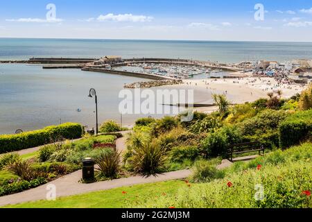 Der Hafen und der Strand von Lyme Regis, von den Langmoor und Lister Gardens an der Jurassic Coast, Dorset, Großbritannien aus gesehen Stockfoto