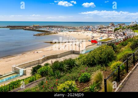 Der Hafen und der Strand von Lyme Regis, von den Langmoor und Lister Gardens an der Jurassic Coast, Dorset, Großbritannien aus gesehen Stockfoto