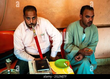 Assuan, Ägypten - Januar 4 2011: Ägyptischer Mann, der in einem Café eine Shisha-Wasserpfeife oder Hookah geraucht hat Stockfoto