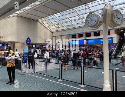 Flughafenmitarbeiter leitet Passagiere an einem geschäftigen Reisetag am Orlando International Airport (MCO) zur TSA-Screening- und Sicherheitslinie weiter. Stockfoto