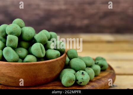 wasabi beschichtete Nüsse mit einem Holzhintergrund Stockfoto