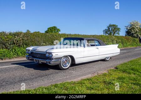 1960 60er Jahre weißes amerikanisches Linkshandlaufwerk USA Cadillac 6390cc 2dr Cabriolet, auf dem Weg zur Capesthorne Hall classic May Foreign Car Show, Ceshire, UK Stockfoto