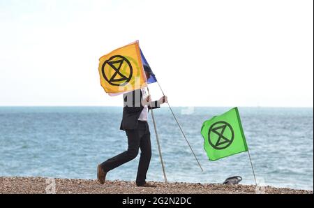 Worthing Sussex UK 12. Juni 2021 - Aktivisten des Extinction Rebellion nehmen heute am Worthing Beach Teil an einem Aktionswochenende anlässlich des G7-Gipfels und heben die Auswirkungen des Klimawandels und des steigenden Meeresspiegels hervor: Credit Simon Dack / Alamy Live News Stockfoto