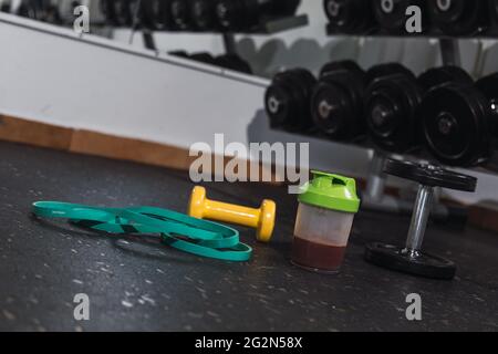 Protein Shake und Hanteln im Fitnessstudio. Fitness Ernährung Getränk und schwere Gewichte.P Stockfoto