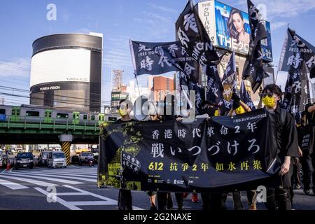 Tokio, Japan. Juni 2021. Während der Demonstration halten die Demonstranten ein Banner und Flaggen in der Hand. Prodemokratische Demonstranten gingen in Shinjuku, Japan, auf die Straße, um den zweiten Jahrestag der Anti-Auslieferungsgesetz-Bewegung Hongkongs zu begehen. (Foto von Viola kam/SOPA Images/Sipa USA) Quelle: SIPA USA/Alamy Live News Stockfoto