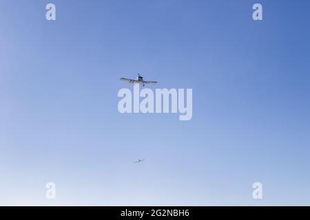 „Durch klaren Himmel fliegen: Zwei Flugzeuge navigieren durch die weite blaue Weite und verkörpern die Freiheit und das Abenteuer des Fluges in einem ruhigen Lufttanz.“ Stockfoto