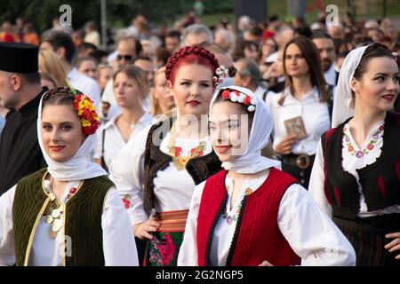 Belgrad, Serbien - 10. Juni 2021: Junge Volkstänzerinnen in traditionellen Kostümen nehmen an einer religiösen Prozession Teil, um Belgrads P zu feiern Stockfoto