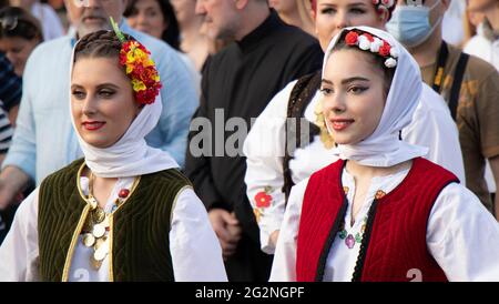 Belgrad, Serbien - 10. Juni 2021: Junge Volkstänzerinnen in traditionellen Kostümen nehmen an einer religiösen Prozession Teil, um Belgrads P zu feiern Stockfoto