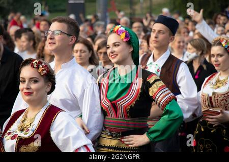 Belgrad, Serbien - 10. Juni 2021: Junge Volkstänzer in traditionellen Kostümen nehmen an einer religiösen Prozession Teil, um die Belgrader zu feiern Stockfoto