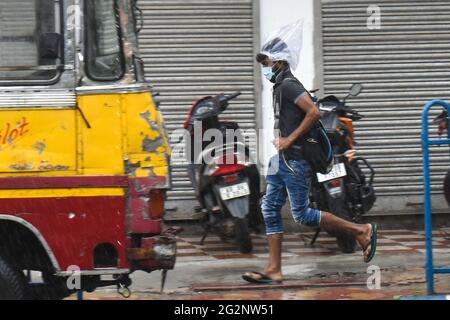 Kalkutta, Indien. Juni 2021. Ein Mann bedeckte seinen Kopf mit Kunststoffen, die während starker Regenfälle während eines Coronavirus-Notfalls in Kalkutta auf der Straße liefen. (Foto von Sudipta das/Pacific Press) Quelle: Pacific Press Media Production Corp./Alamy Live News Stockfoto