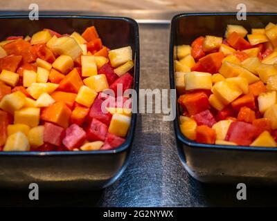 Frisch geschnittenes Obst in einer schwarzen Schüssel am Buffettisch. Selektiver Fokus auf Früchte. Stockfoto