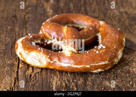 bayerische Butterbrezel auf dunklem Holz Stockfoto