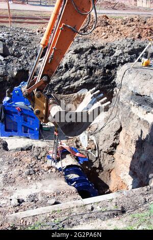 Samara, Russland - 06. Mai 2021: Nahaufnahme eines Baggerschaufels, der Erdarbeiten auf einer Baustelle durchführt Stockfoto