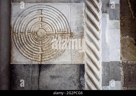 Kathedrale von Lucca (Toskana, Italien). Detail der alten berühmten Labyrinth-Säule an der Fassade, verziert mit einem mittelalterlichen Labyrinth über dem weißen Marmor Stockfoto
