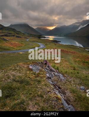 Kurvenreiche Single Track Road Führt Durch Grüne Abgeschiedene Landschaft Mit Schönem Sonnenaufgang. Wastwater, Lake District, Großbritannien. Stockfoto