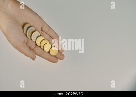 Draufsicht auf Münzen in der Hand. Ausgaben und Erträge. Konzept von Almosen und Spenden. Geringe Einsparungen. Stockfoto