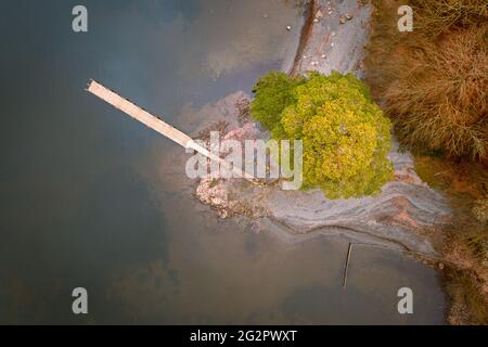 Luftaufnahmen aus der Vogelperspektive von einem langen hölzernen Steg an der Küste der Insel im Lake District, Großbritannien. Stockfoto