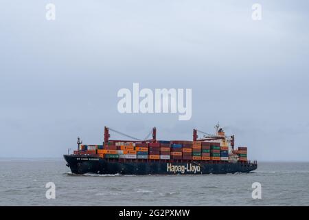 Brunsbüttel, Deutschland - 25. Mai 2021: Blick auf ein großes Hapag-Lloyd Containerschiff auf dem offenen Ozean unter bewölktem Himmel Stockfoto