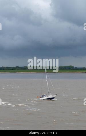 Cuxhaven, Deutschland - 25. Mai 2021: Kleines Segelboot gegen Wetter und Strömung in der Elbmündung Stockfoto