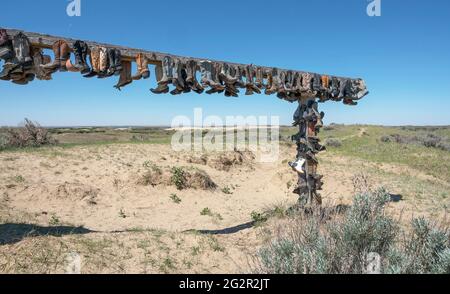 Alte Cowboystiefel wurden in den Great Sandhills (Sand Hills) in der Nähe von Scepter, Saskatchewan, Kanada, an eine Schiene genagelt Stockfoto