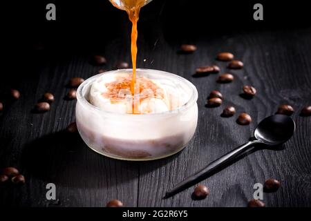 Vanilla-Affogato mit heißem Kaffee auf schwarzem Holz Hintergrund gekrönt Stockfoto