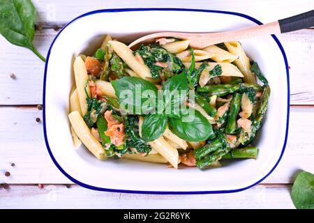 Spinat mit Lachs, Blauschimmelkäse und Spargel in einer Emaille-Schüssel Stockfoto