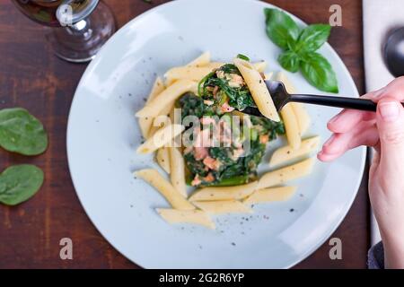 Spinat mit Lachs, Blauschimmelkäse und Spargel auf einem Teller Stockfoto