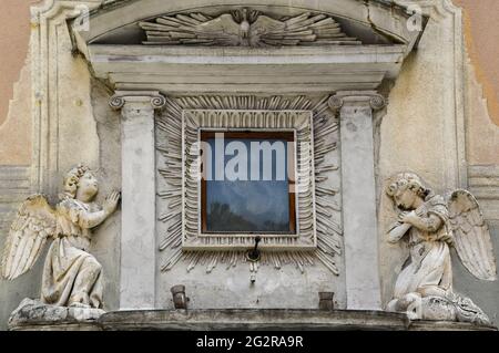 Nahaufnahme eines Votivschreines an der façade eines alten Gebäudes mit einem Fresko der hl. Marie und zweier Engel in Anbetung, Via San Vincenzo, Genua, Italien Stockfoto