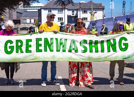 Falmouth, Cornwall, Großbritannien 2021 12. Juni ‘Aussterbungsrebellion marschiert aus Protest gegen die „Greenwashing“-Politik von Wirtschaft und Regierung beim G7-Gipfel. Die roten Rebellen führten den marsch durch das Stadtzentrum, zusammen mit den Ärzten von XR und schmutzigen Wäschern, und endeten am Medienzentrum. Stockfoto