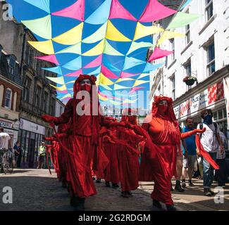 Falmouth, Cornwall, Großbritannien 2021 12. Juni ‘Aussterbungsrebellion marschiert aus Protest gegen die „Greenwashing“-Politik von Wirtschaft und Regierung beim G7-Gipfel. Die roten Rebellen führten den marsch durch das Stadtzentrum, zusammen mit den Ärzten von XR und schmutzigen Wäschern, und endeten am Medienzentrum. Stockfoto